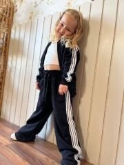 Siyah üzerine beyaz çizgili fermuarlı takım